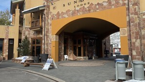 Lodge Sundial, con fachada de piedra, una amplia entrada en arco y un letrero que indica que no se permite estacionamiento.