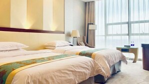 Une chambre d’hôtel avec deux lits, un bureau, une chaise et une grande fenêtre avec des rideaux.