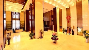Un hall d’entrée spacieux, doté de hauts plafonds, de grandes fenêtres et d’un espace salon central.