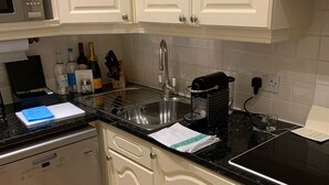 A kitchen with white cabinets, a Bosch microwave, a dishwasher, and a sink with a faucet. - 2-nights accommodation at 1-Bedroom Executive Residence in London (London)