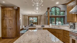 Una cocina amplia con encimeras de granito, gabinetes de madera y una isla grande.
