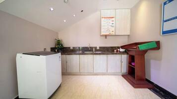 A kitchen with a refrigerator, sink, and wooden counter.