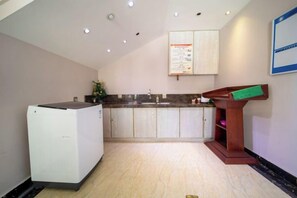 A kitchen with a refrigerator, sink, and wooden counter.