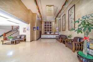 A spacious lobby with a marble floor, a reception desk, seating area, and a staircase. - Jensland Hotel (Fuqing)