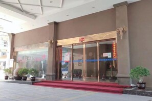 A hotel entrance with a red carpet, glass doors, and a sign above the entrance. - Jensland Hotel (Fuqing)