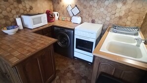 Una cucina funzionale con lavatrice, forno a microonde, tostapane e lavello.