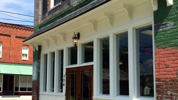 A two-story building with a white porch and a brick facade.