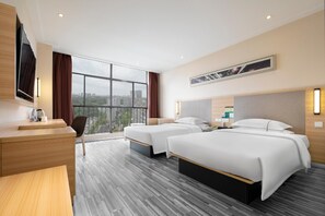 A hotel room with two beds, a desk, a chair, a TV, and a large window with a city view. - City Convenient Hotel (Yichang)
