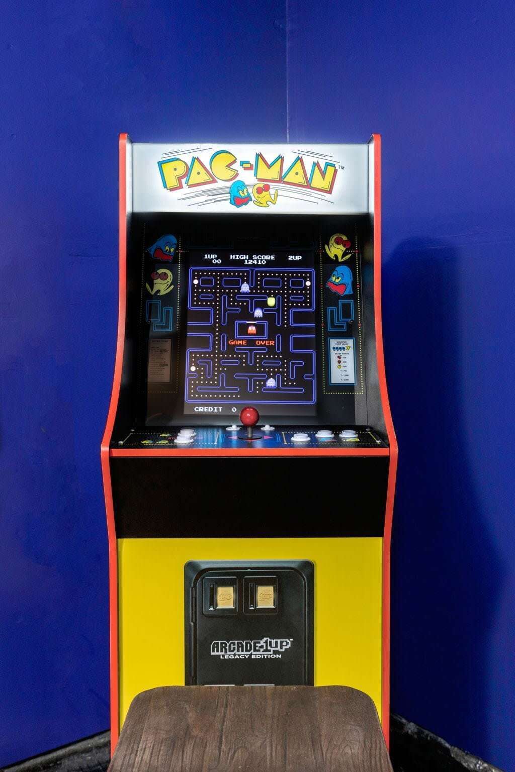 A Pac-Man arcade machine with a yellow and black color scheme, a game over screen, and a 'CREDIT' button.
