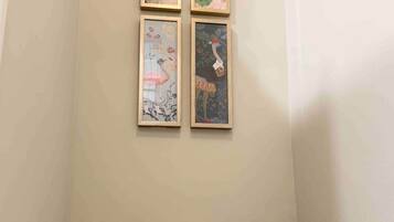 Un baño con inodoro y cuatro obras de arte enmarcadas en la pared.