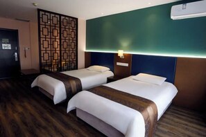 A hotel room with two beds, a decorative partition, a wall-mounted air conditioner, and a wooden floor. - Ripple Hotel (Weihai Wendeng Bus Station) (Weihai)