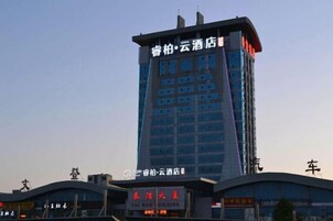 Un edificio de hotel con varios pisos y un letrero llamativo en la parte superior.