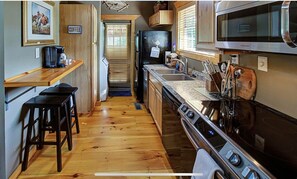 Enjoy cooking in this well-equipped kitchen with a central island, sink, and stainless steel stove.