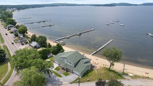 A lakeside property with a house, dock, and boats. - The Eastside ~ Modern Coastal Getaway w/ Pool, Private Beach, Sauna and Dock (Colchester)