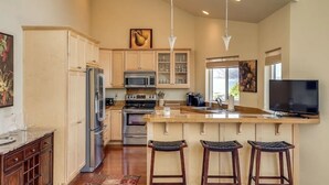 A spacious kitchen with a central island, stainless steel appliances, and a large window providing natural light. - Lake Chelan Waterfront Resort Home- Pool, Boat -STR-0290 (Chelan)