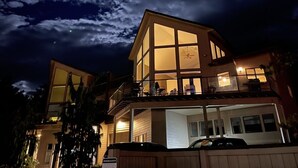 A multi-story house with large windows and a balcony, surrounded by trees. - Lake Chelan Waterfront Resort Home- Pool, Boat -STR-0290 (Chelan)