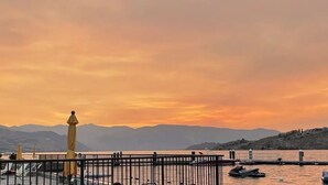 A waterfront view with a pier, boats, and mountains in the background. - Lake Chelan Waterfront Resort Home- Pool, Boat -STR-0290 (Chelan)