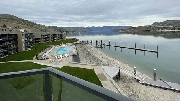A hotel with a pool, a dock, and a view of a lake and mountains. - Lake Chelan Waterfront Resort Home- Pool, Boat -STR-0290 (Chelan)