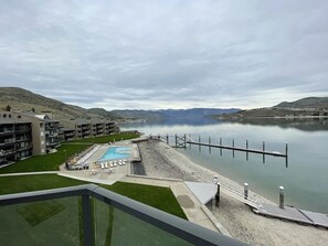 Un hotel con piscina, muelle y vistas a un lago y montañas.