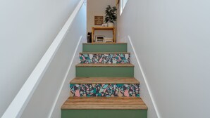 A staircase with green steps and a wooden handrail.