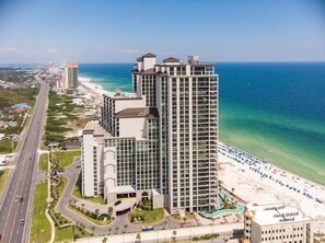 A high-rise hotel with a beach view, multiple floors, and a road adjacent to the property.