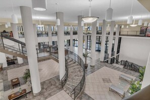 Un vaste atrium doté d’un escalier central, de plusieurs niveaux et de divers espaces aménagés pour s’asseoir.