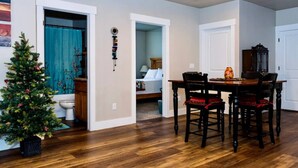 A dining area with a wooden table and chairs, a small Christmas tree, and a hallway leading to a bedroom. - Montague Manor" W&D, Hot Tub, Queen Beds, Sleeps6 (Bluffdale)