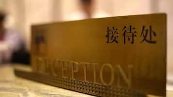 A reception desk with a sign that reads 'RECEPTION' and another sign with Chinese characters.