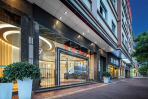 A hotel with a modern facade, large glass windows, and a well-lit entrance. - Meisi Park Lane Hotel (Heshan Qianjin South Road) (Heshan)