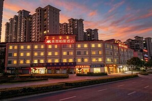 A multi-story hotel with a prominent sign, a well-maintained facade, and a parking lot in front.