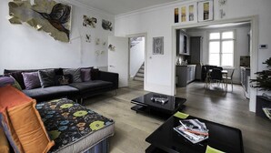 Un saló modern amb un sofà, una taula de centre i una zona de menjador al fons.