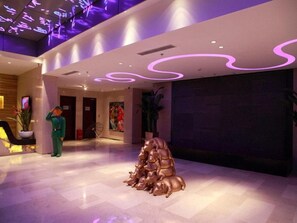 A lobby with a central sculpture, a reception desk, and a large painting on the wall. - Yitel Premium Beijing Wangjing 798 (Beijing)