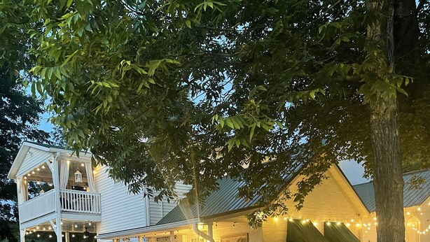 Un bâtiment à deux étages doté d’un balcon et illuminé de guirlandes lumineuses.