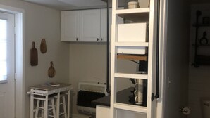 Un espace de vie compact comprenant un espace en mezzanine, une kitchenette et une salle de bain.