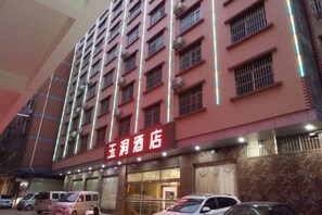 A multi-story hotel with a red facade and illuminated signage. - Nanningyudongjiudian (Nanning)