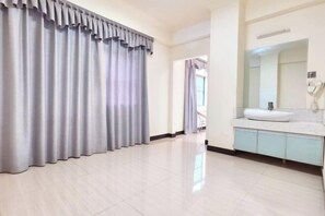 A hotel room with a large window, a bathroom with a sink and mirror, and a curtain covering the window. - Nanningyudongjiudian (Nanning)