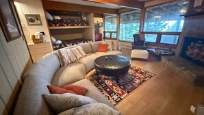 Un salon chaleureux avec un canapé incurvé, une table basse et une cheminée.