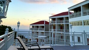 A hotel with multiple balconies, outdoor seating, and a view of the sea.