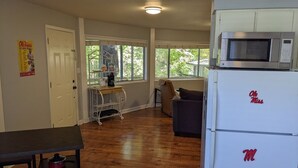 A kitchen with a microwave, refrigerator, and wooden flooring. - DOUBLE DECKER CONDO! LARGE GROUPS! NEXT TO CAMPUS! (Oxford)