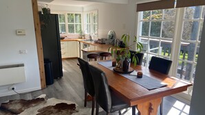Une cuisine moderne avec une table à manger en bois, des chaises et une grande fenêtre.