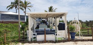 Un cabanon de plage avec des sièges extérieurs, un espace abrité et une vue sur l’océan.