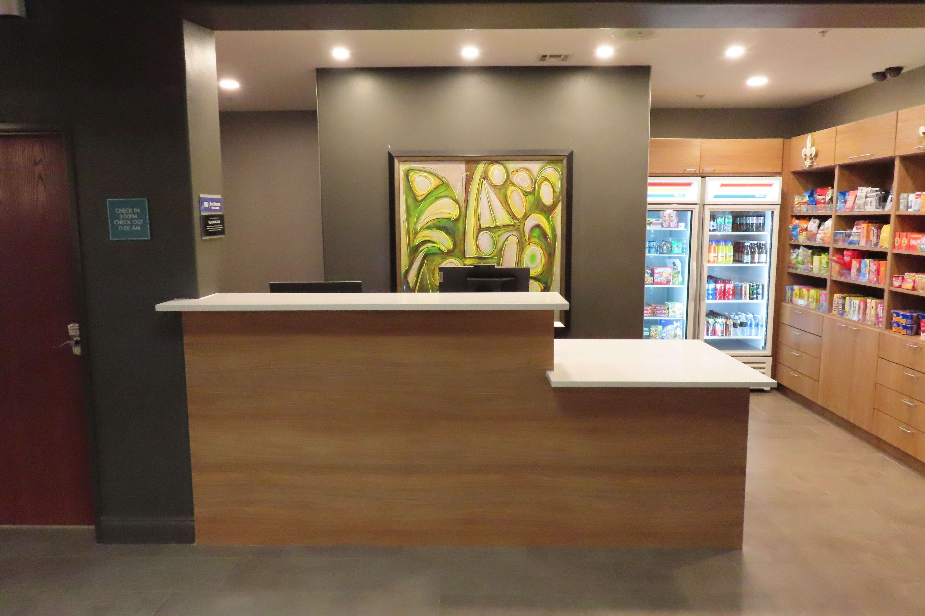 Een receptiebalie met een incheckruimte, een koelkast gevuld met drankjes en een automaat voor snacks.