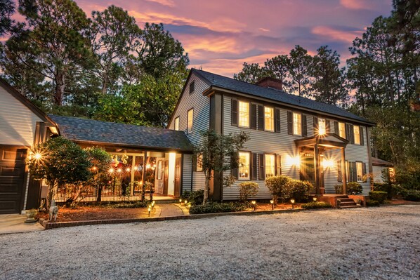 A two-story house with a front porch and a driveway. - Your Private Clubhouse with Golf Simulator and Pool (Pinehurst)