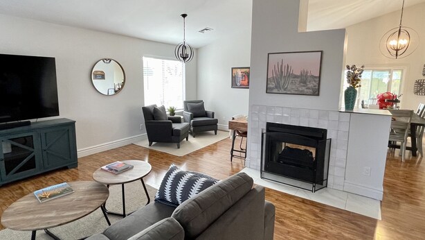 A modern living room with a fireplace, a television, and comfortable seating. - Cactus Oasis -Cheerful 3 bedroom family home with heated pool. (Phoenix)