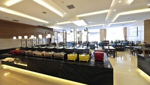 A modern hotel lobby with a marble reception desk, luggage storage, and a dining area with tables and chairs. - Beijing Post & Telecom Conference Centre (Beijing)
