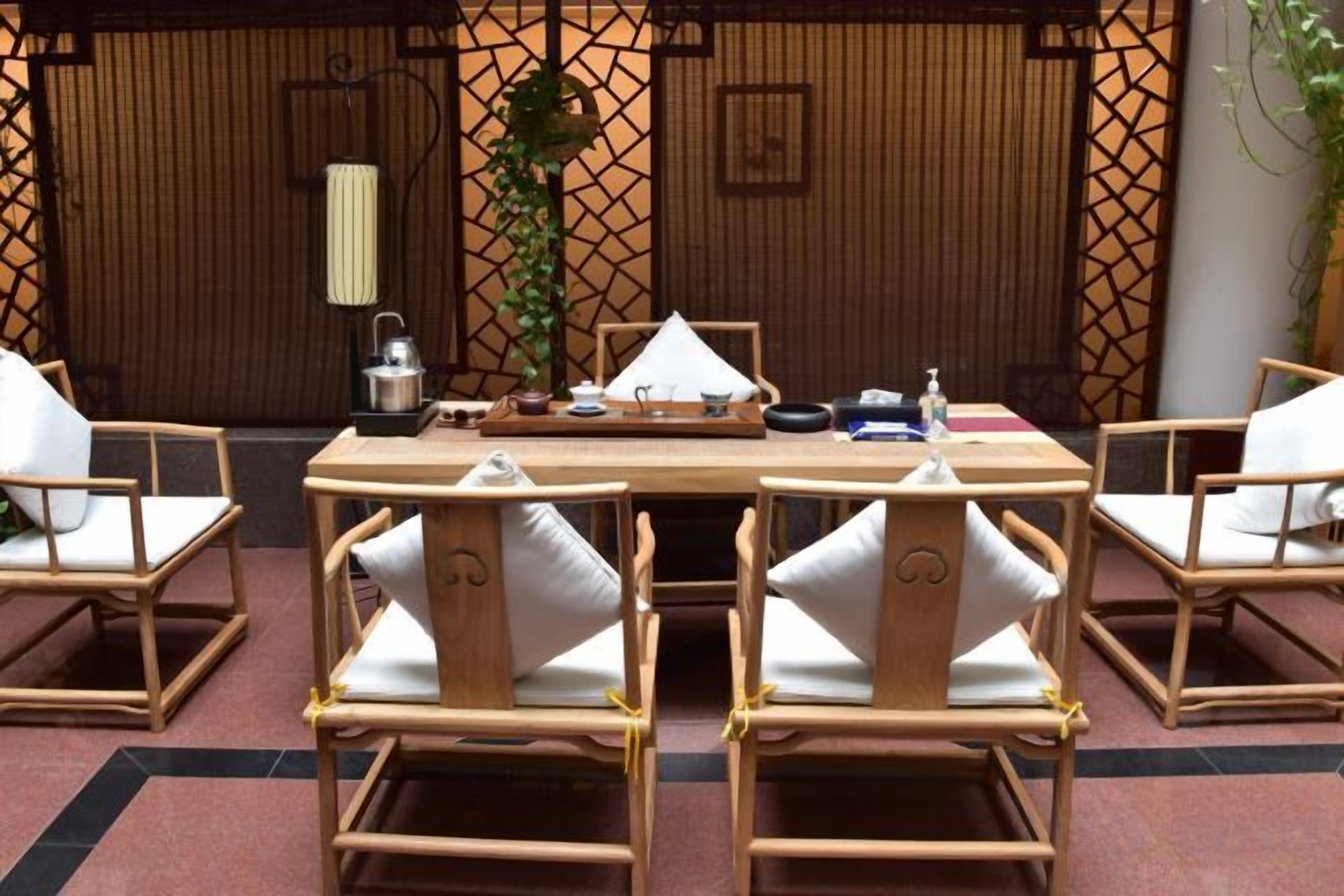 Una camera in stile tradizionale giapponese, con pavimento in tatami, un tavolino e sedie di legno.