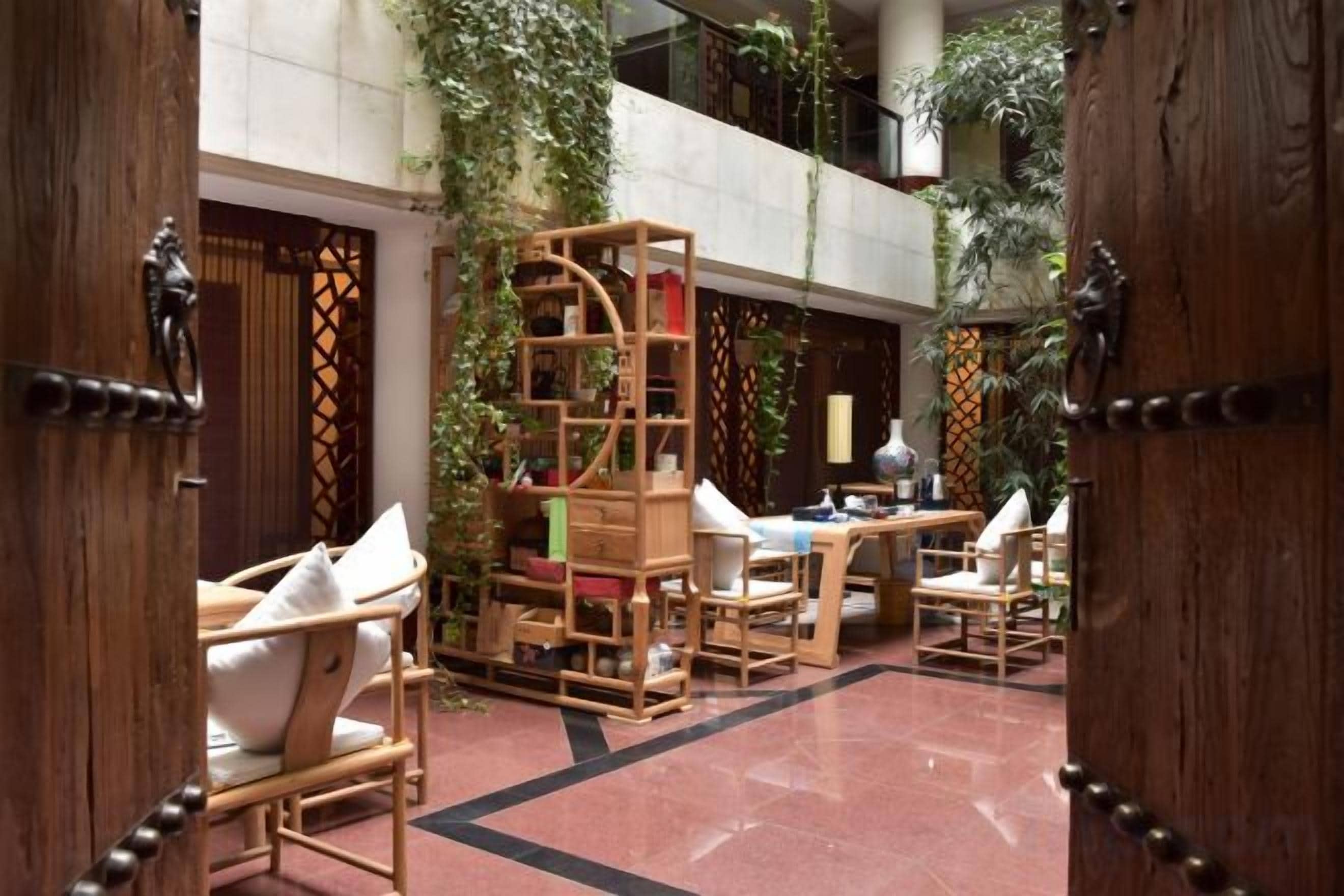 A spacious indoor area with wooden furniture and a central wooden structure, possibly a bookshelf or display unit.