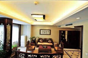 A traditional-style living room with a sofa set, a coffee table, and a decorative wall piece. - Beijing Post & Telecom Conference Centre (Beijing)