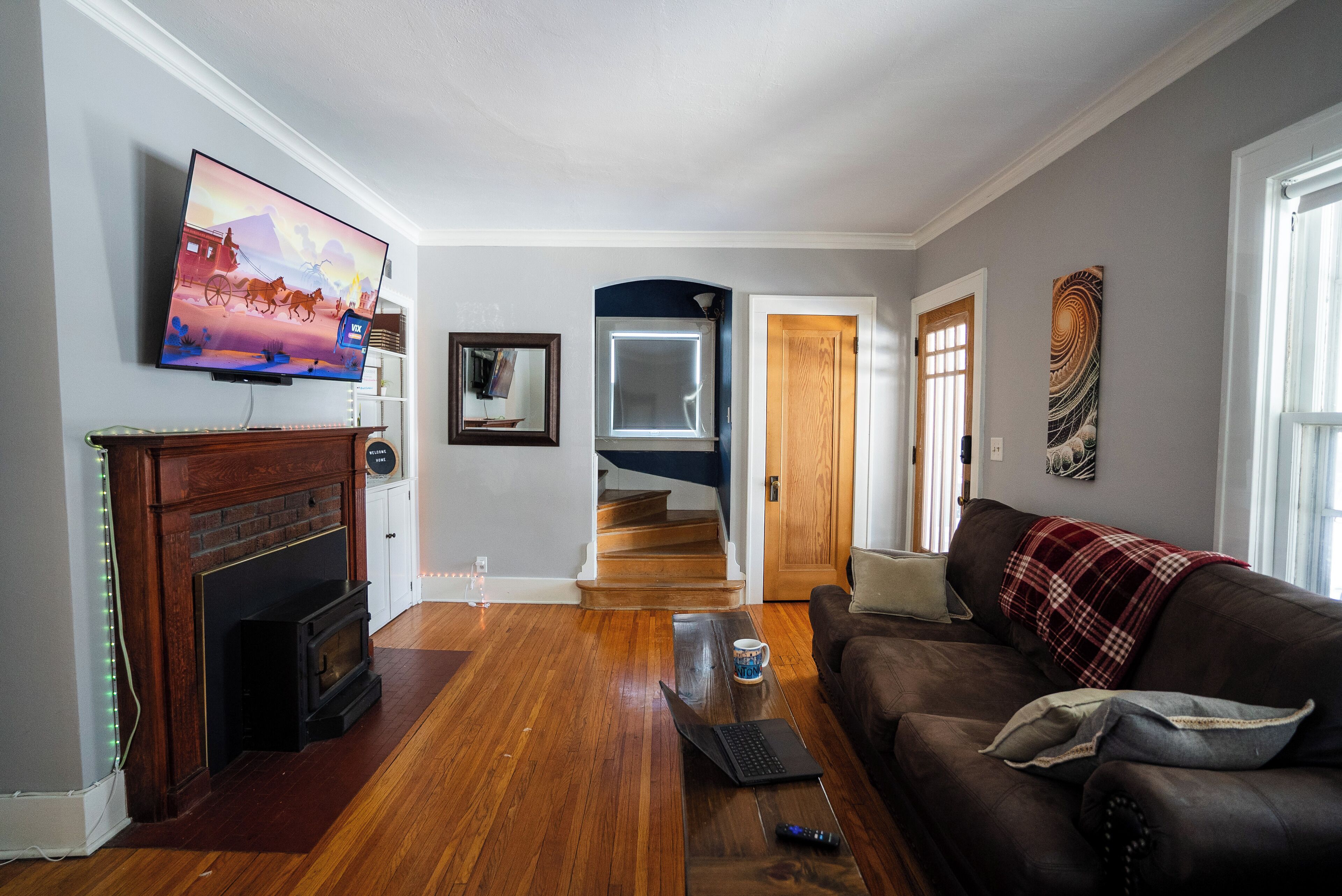 TV connectée, cheminée, livres, écrans d'ordinateur