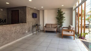 A spacious lobby with a reception desk, a sofa, and a chair. - Hotel Atlântico Sul (Ipojuca)